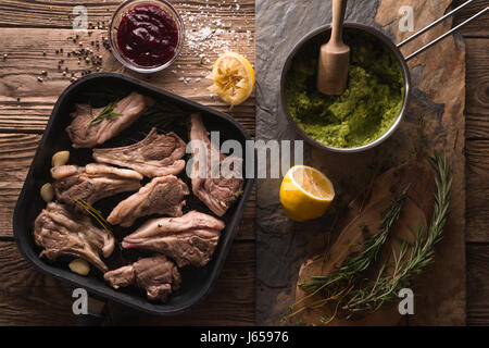 Costolette di agnello grigliate e purè di patate in una siviera e salsa di barbabietole Foto Stock