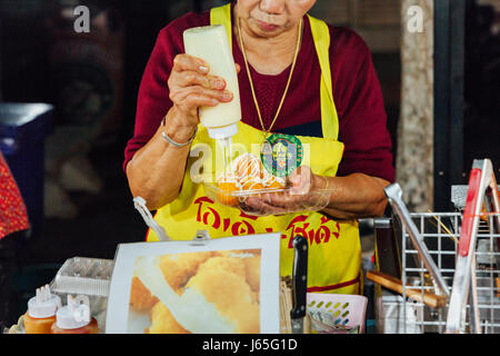 CHIANG MAI, Thailandia - 21 agosto: Donna di preparare il cibo per la vendita al mercato di domenica (walking street) il 21 agosto 2016 a Chiang Mai, Thailandia. Foto Stock