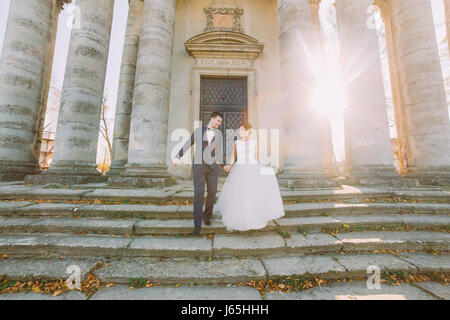 Foto romantica della sposa giovane andando giù per le scale del palazzo antico. Foto Stock