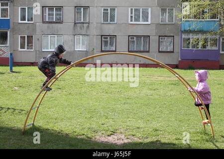 Due sorelle Vivid Riproduci sul arcobaleno nel parco della città in un caldo giorno di primavera Foto Stock