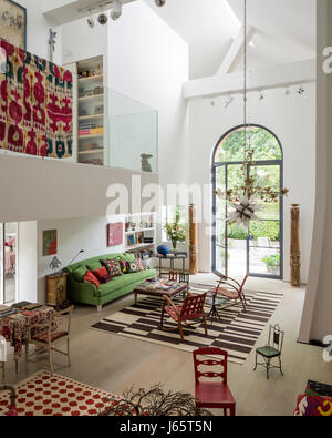 Triple-altezza spazio soggiorno con soppalco e vecchi prodotti tessili l'aggiunta del colore Foto Stock