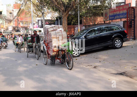 Lavoro duro indiani spingendo il carico pesante attraverso strade di Delhi, India nel febbraio, 13, 2016. Foto Stock