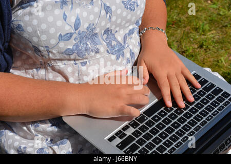 Adolescente utilizzando il trackpad su computer portatile all'aperto, Foto Stock