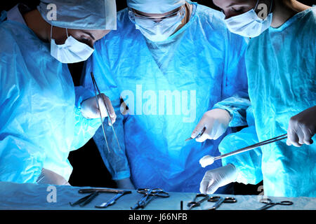 Il team medico di eseguire l'operazione. Gruppo di chirurgo a lavorare in sala operatoria tonica in blu Foto Stock