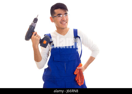 Uomo in generale con guanti e occhiali di protezione tenendo cacciavite elettrico Foto Stock