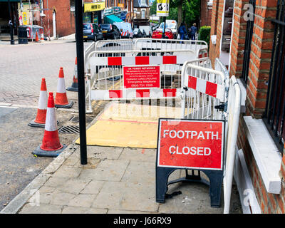 Rosso e bianco marcatori di avvertimento, coni e scherma, sentiero chiusa per riparazioni a Islington, a nord di Londra, Regno Unito Foto Stock