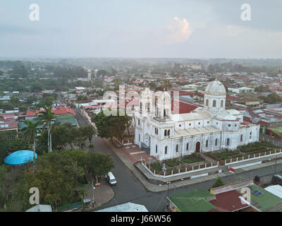 Piccola cittadina in nebbiosa mattina tempo vista aerea. Cattedrale cattolica del centro città di piccole dimensioni Foto Stock