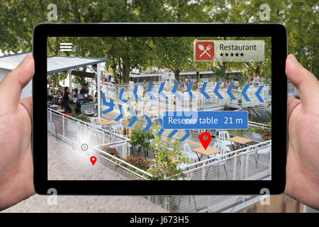 Augmented Reality technology , Navigazione virtuale concetto. Mano azienda tablet con grafico di applicazione AR schermo per mostrare la tabella di riserva in restaura Foto Stock