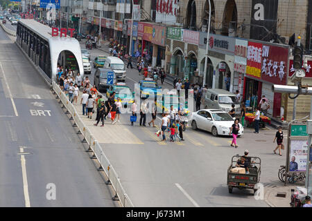 Pedoni e il traffico al Bus Rapid Transit Station, Yinchuan, Ningxia, Cina Foto Stock