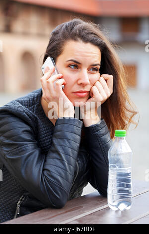 Sconvolto bella donna parla al telefono Foto Stock