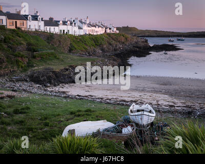 Portnahaven sull'isola scozzese di Islay che mostra le barche, la spiaggia e il villaggio di pescatori cottage al tramonto, rosa al tramonto. Foto Stock