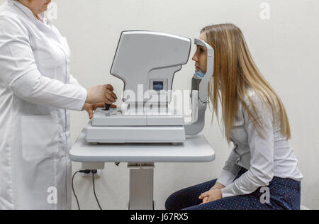 Attenti all'ottico optometrista esame paziente femmina su lampada a fessura in Oftalmologia Clinica Foto Stock