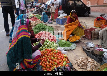 JAIPUR, India - 16 febbraio: le donne indiane in Colorati luminosamente sari comprare la frutta e la verdura dal lato della strada a Jaipur, Rajasthan, India su Foto Stock