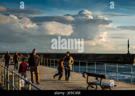 Aberystwyth Wales UK, Sabato 20 Maggio 2017 UK Meteo: gente camminare lungo Aberystwyth promenade di sera come drammatica aria di tempesta dietro di loro su Cardigan Bay sulla West Wales coast Photo credit Keith Morris / Alamy Live News Foto Stock