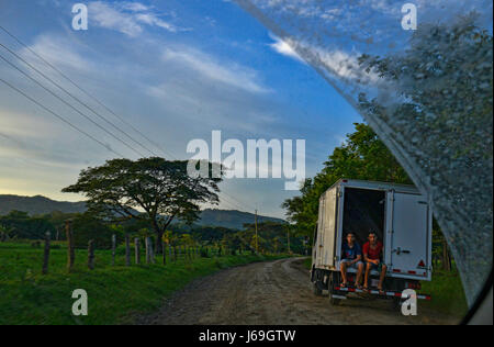 Due bambini viaggiare nel retro di un camion su una strada sterrata in Sámara, Costa Rica. Foto Stock