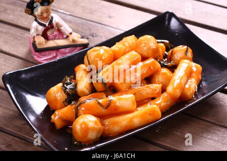 Il coreano Tteokbokki con salsa di peperoncino sul piatto nero Foto Stock