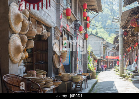 Hongya, nella provincia di Sichuan, in Cina - il Apr 29, 2017: più oggetti di paglia in un piccolo negozio in una stretta strada borgo antico Foto Stock