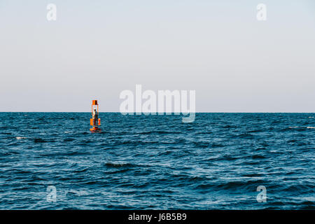 Spia di avvertimento rossa galleggianti in mezzo all'oceano Foto Stock