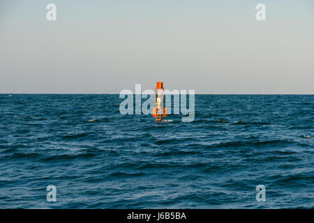 Spia di avvertimento rossa galleggianti in mezzo all'oceano Foto Stock