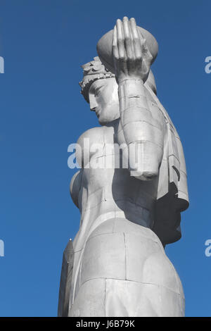 Kartvlis Deda alluminio questa statua di una donna in stile georgiano tradizionale costume con un bicchiere di vino in una mano e una spada nell'altro. Foto Stock