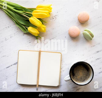 Vista superiore del notebook, caffè, macarons e tulipani su Sfondo marmo Foto Stock