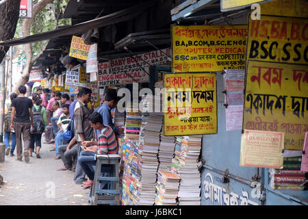 Gli studenti check out libri a una vecchia strada laterale prenota stallo a College Street del mercato del libro in Kolkata, India Foto Stock