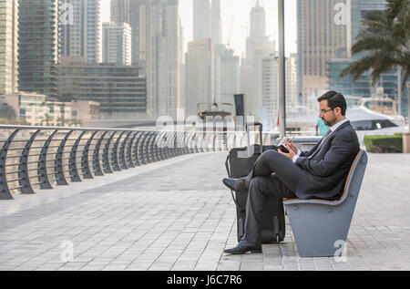 Imprenditore seduto e prendere appunti in Marina di Dubai, UAE Foto Stock