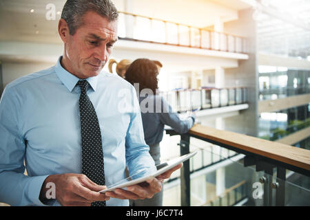 Coppia business man standing e navigazione in Internet Tablet PC in ufficio. Foto Stock