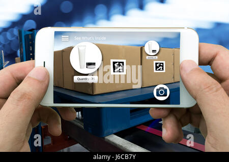 Logistic , Augmented Reality marketing , X-Ray confezioni concetto. Mano che tiene il telefono cellulare per verificare gli elementi all'interno di scatole. Foto Stock