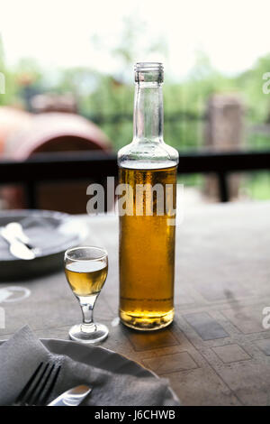 Vecchio brandy alla prugna in vetro su tavola Foto Stock