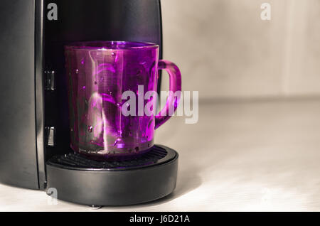 Coppa viola su di una macchina per il caffè espresso, uno spazio vuoto a destra del testo Foto Stock