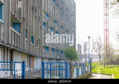 Consiglio alloggiamento piatto blocco, Robin Hood Gardens, nella zona est di Londra con un edificio rosso gru in background Foto Stock
