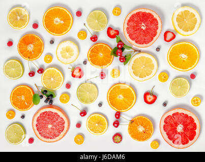 Piatto trendy laici seamless pattern affettati misti agrumi come sfondo con diverse bacche, concetto di mangiare sano, dieta, dall'alto verso il basso Foto Stock