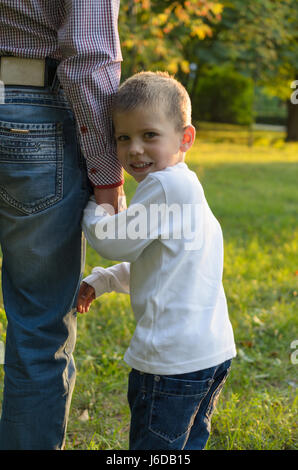 Amare il papà porta il suo figlio la mano. Il Bambino guarda indietro. Foto Stock