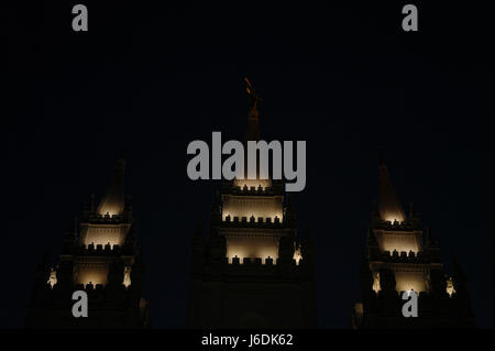 Vista notturna di guglie illuminate, con angelo Moroni sugli alti guglia centrale, dal lato est del Tempio di Salt Lake, Temple Square, Salt Lake City, Utah Foto Stock