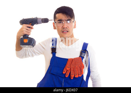 Uomo in generale con guanti e occhiali di protezione tenendo cacciavite elettrico Foto Stock