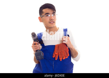 Uomo in generale con guanti e occhiali di protezione tenendo cacciavite elettrico Foto Stock