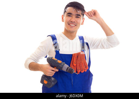 Uomo in generale con guanti e occhiali di protezione tenendo cacciavite elettrico Foto Stock