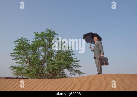 Imprenditore scoprire qualcosa nel mezzo del deserto Foto Stock