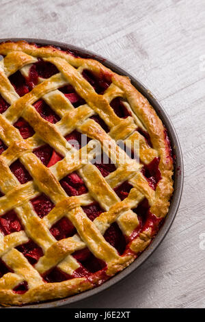 Tutta la torta alle fragole su bianco tavolo in legno Foto Stock