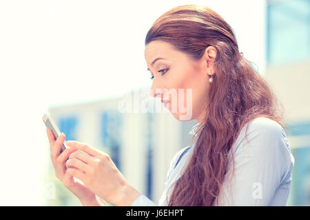 Primo piano laterale verticale del profilo sconvolto triste scettico infelice donna gravi parlando texting sul telefono, orinato con conversazione città isolata backgroun Foto Stock