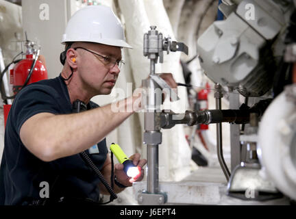 Sergey Amosov, USNS Trenton secondo ingegnere, ispeziona i componenti del motore durante una routine di controllo di manutenzione. Trenton, uno di solo otto Expeditionary Fast navi da trasporto militari Sealift Command di inventario, ha recentemente completato un annuale di un bacino di carenaggio revisione a Marsiglia, Francia. Foto Stock