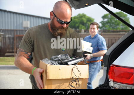 John Carter, 78Ingegnere Civile Rottami di metallo cantiere Operations Manager consente di Christopher Venerdì, chief engineer C2ISR progetto speciale, per effettuare il suo vecchio computer e periferiche per l'E-Box in bicicletta. Come parte della Giornata della Terra 2017, il 78 Ingegnere Civile gruppo ospitato un annuale E la bicicletta al giorno presso la Robins Centro di riciclaggio, 28 aprile 2017. Circa 2.800 libbre di vecchi computer, monitor e altri prodotti elettronici sono stati raccolti in 4 ore. (U.S. Air Force foto di Misuzu Allen) Foto Stock