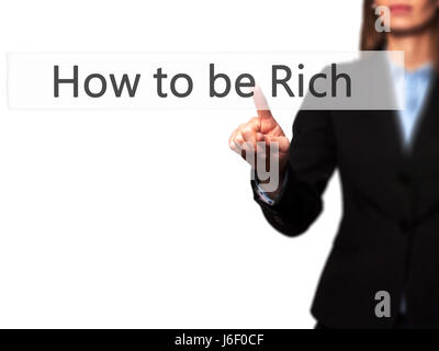 Come essere ricco - Imprenditrice mano premendo il pulsante sul touch screen interfaccia. Business, tecnologia internet concetto. Stock Photo Foto Stock