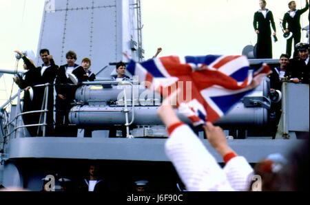 AJAXNETPHOTO. 19Giugno. 1982. PORTSMOUTH, Inghilterra. - Superstite restituisce - la bomba ha danneggiato tipo 42 (1&2) SHEFFIELD Cacciatorpediniere classe (3660 tonnellate) HMS GLASGOW arriva a casa per un caloroso benvenuto da bandiera sventola una folla di ben wishers. Foto:JONATHAN EASTLAND/AJAX. REF:910820 Foto Stock