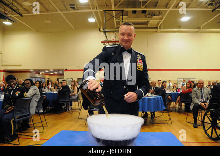 Col. Frederick Thaden, comandante della base comuneGuire-Dix Mc-Lakehurst, New Jersey, versa un ingrediente nel grog ciotola durante gli Stati Uniti Esercito della riserva 99th regionale di comando supporto per cenare fuori il 12 maggio su JBMDL. Il tema della manifestazione era "veterani: Ieri e Oggi". Più di 100 reduci dal veterano area case sono state invitate a partecipare. Foto Stock