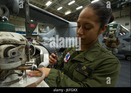 170515-N-ZQ712-0004 OCEANO PACIFICO (15 maggio 2017) lancia Cpl. Carissa Flores, a New Orleans native, assegnato al XV Marine Expeditionary Unit (MEU), sabbie adesivo off di un rotore di un MV-22 Osprey nell'hangar bay dell'assalto anfibio nave USS America (LHA 6). Più di 1.800 marinai e 2.600 marines assegnato all'America anfibio gruppo pronto (ARG) e il quindicesimo MEU stanno attualmente conducendo un composito unità di addestramento Esercizio (COMPTUEX) al largo della costa della California del Sud in preparazione per la ARG della distribuzione entro la fine di quest'anno. America ARG è costituito d'America, il dock anfibio la Foto Stock