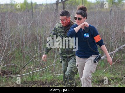 Lisbeth Maidment, un direttore sul campo con contenitore Allied Systems Inc., da Calgary, Alberta, accompagnatrici simulato un incidente durante un realistico casualty scenario di evacuazione come parte di esercizio Maple risolvere 17 a Camp Wainwright, Alberta. Esercizio Maple risolvere 17 è l'esercito canadese del più grande evento di formazione dell'anno coinvolgendo circa 4 mila soldati canadesi, 1.000 U.S. Soldati e servicemembers dalla Gran Bretagna, Australia, Nuova Zelanda e Francia, tenutasi il 14 maggio a 29. Foto Stock