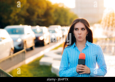 Sorpreso Reporter femmina sul campo nel traffico Foto Stock