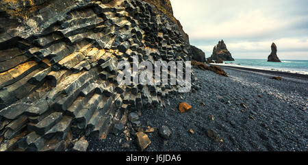 Il basalto formazioni rocciose "Troll delle dita sulla spiaggia nera. Reynisdrangar, Vik, Islanda Foto Stock